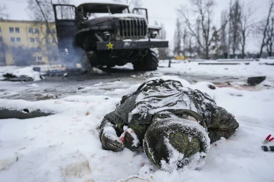 Тело военнослужащего засыпано снегом рядом с уничтоженной российской военной реактивной системой залпового огня на окраине Харькова, Украина, 25 февраля 2022 г. Фото: AP
