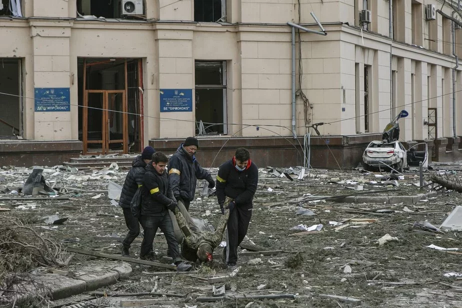 Добровольцы выносят жертву обстрела из здания мэрии в Харькове, Украина, 1 марта 2022 г. Фото: AP