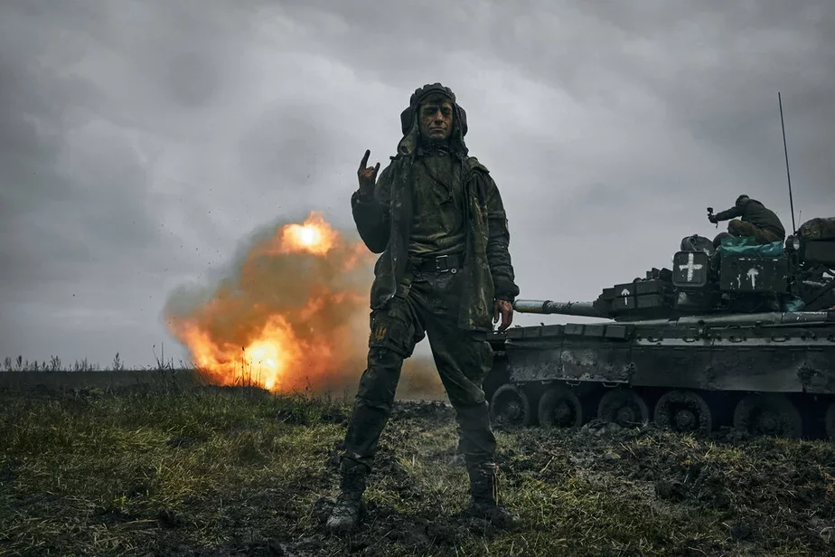 Украінскі салдат пазіруе на фоне падбітага расійскага танка Т-80. Фота: AP Photo/LIBKOS