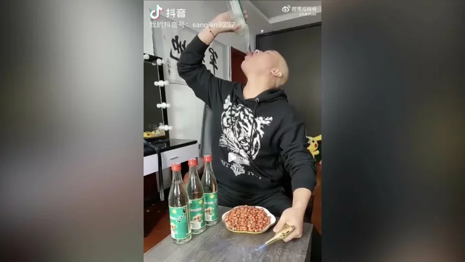 Блогер по фамилии Ван под ником Sanqiange пьет Baijiu во время прямого эфира в Douyin, китайской версии TikTok. Скриншот живого эфира Douyin