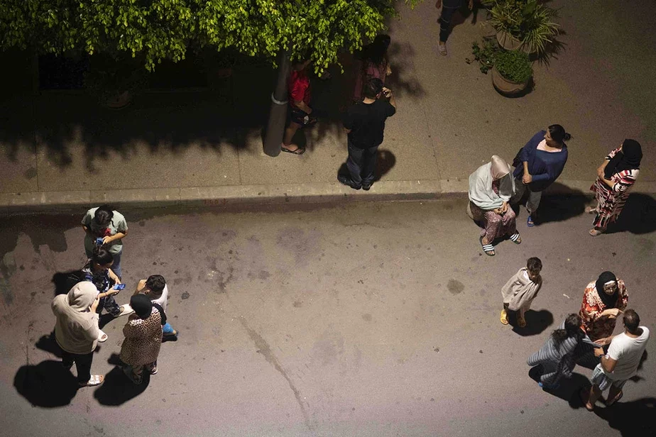 Ludzi chavajucca i praviarajuć naviny na svaich mabilnych telefonach paśla ziemlatrusu ŭ Rabacie, Maroka, u piatnicu, 8 vieraśnia. Fota: Mosa'ab Elshamy / AP