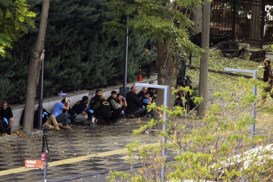 Сотрудники турецкой полиции прячутся, пока эксперты по обезвреживанию бомб работают в районе после взрыва в Анкаре, воскресенье, 1 октября 2023 года. Фото: Ali Unal / AP