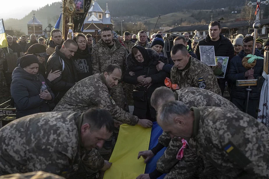 Украинские военные над гробом офицера Василия Матвийчука на кладбище в Карпатах в деревне Красник. Фото: Evgeniy Maloletka / AP